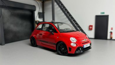 Abarth 595 rouge à bandes noires miniature dans un garage