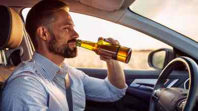 Homme en train de boire de l'alcool au volant