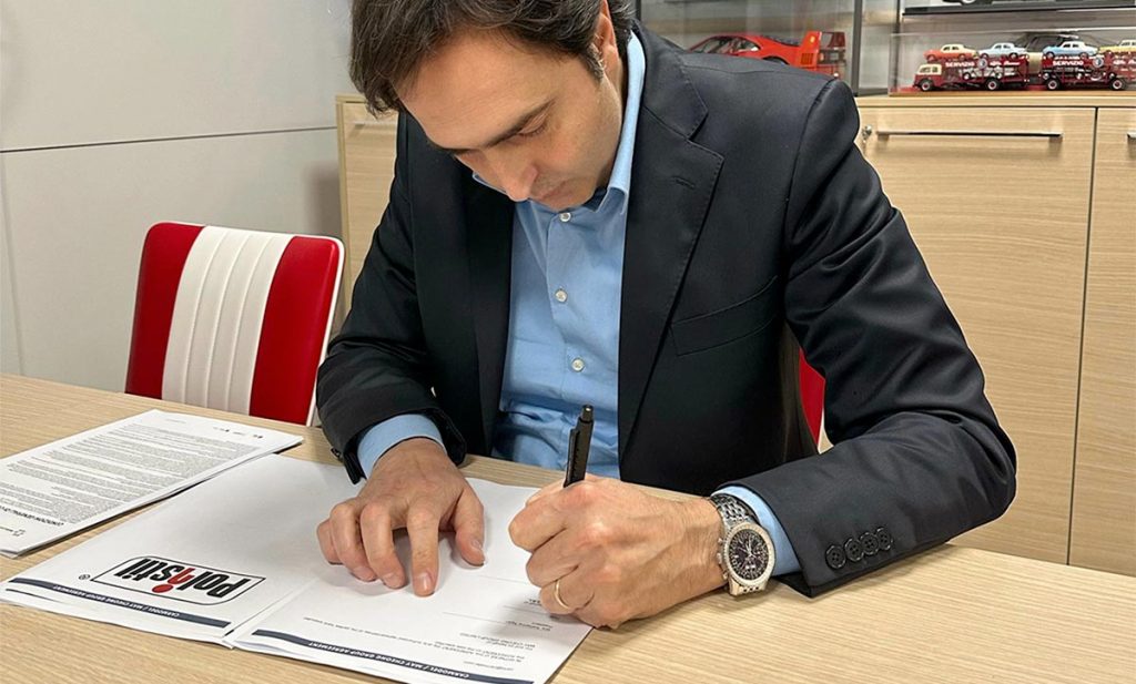 Carlo Pretaroli signe un document dans son bureau