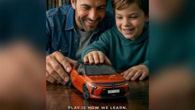 Illustration présentant un père et son fils regardant une Lancia Ypsilon HF orange à l'échelle 1/18